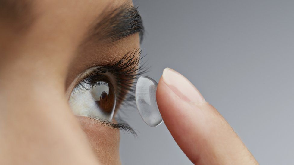 Person putting in a soft contact lens