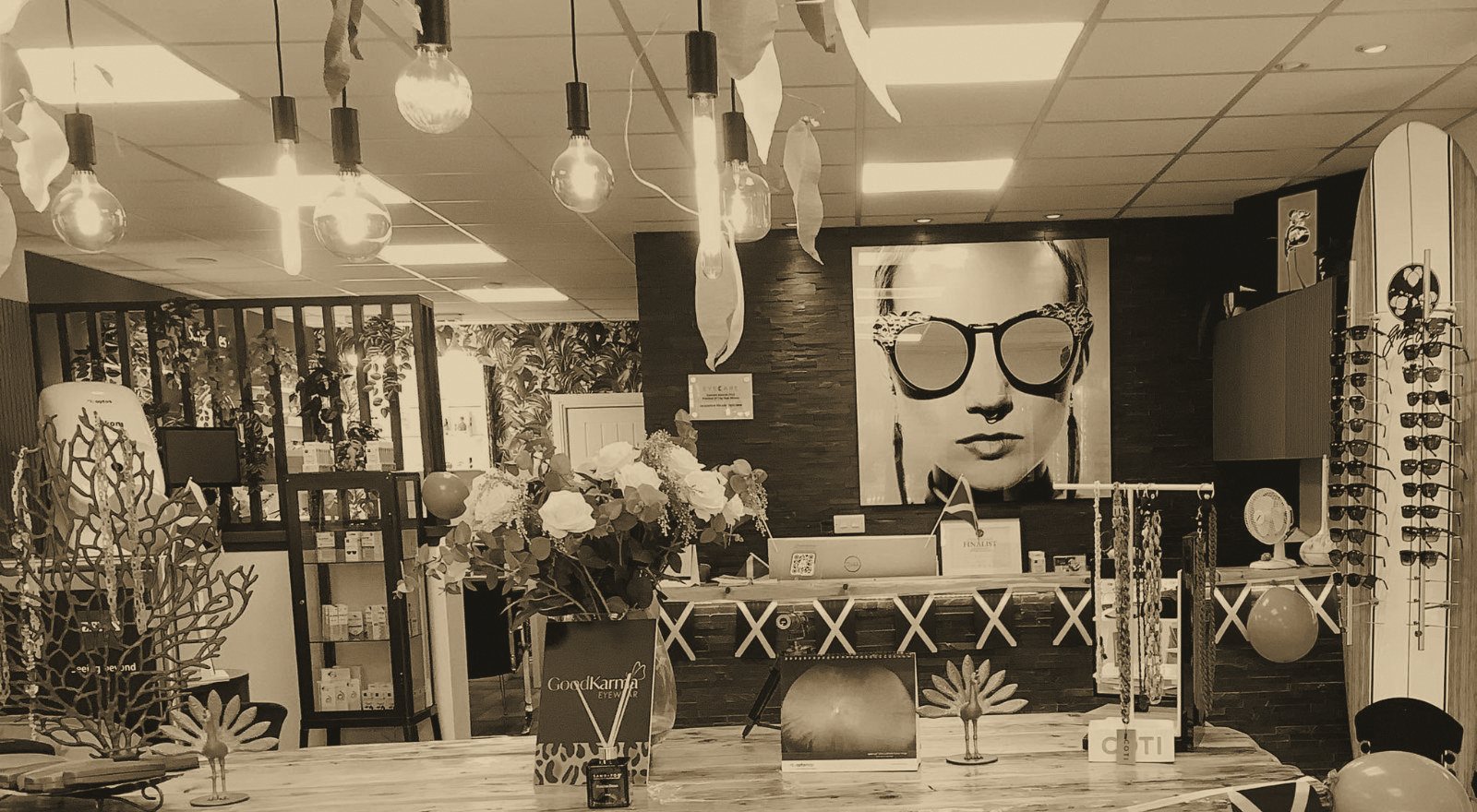 The boutique in gold and ink tones, with a portrait in mirrored sunglasses