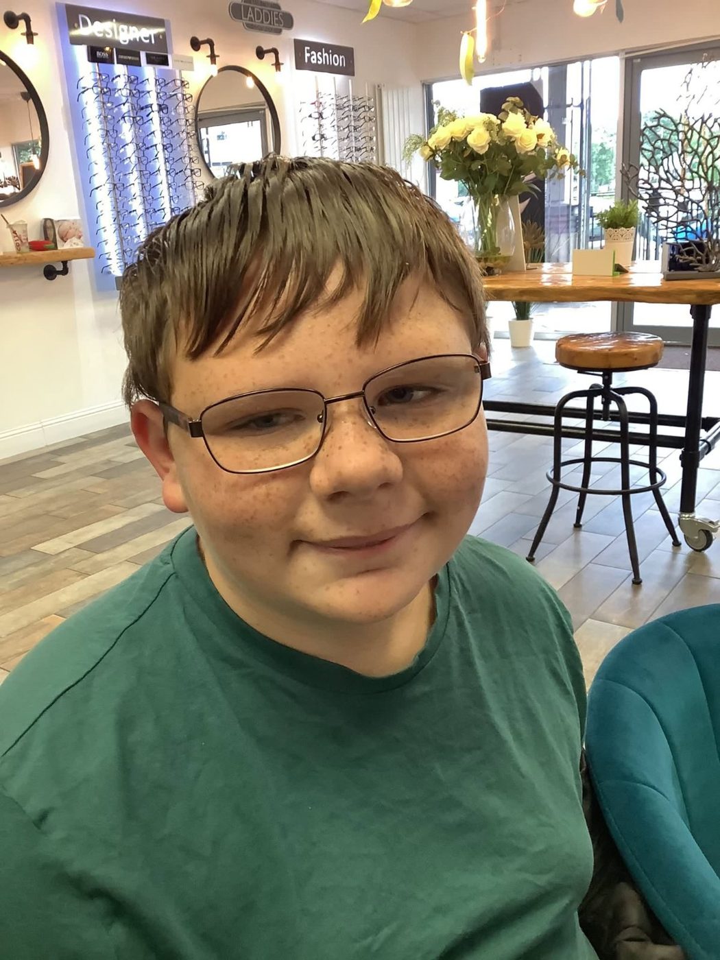 A young patient smiling in his new glasses